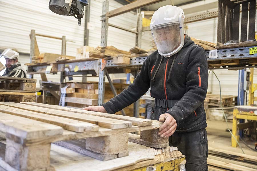 Ouvrier réparant une palette